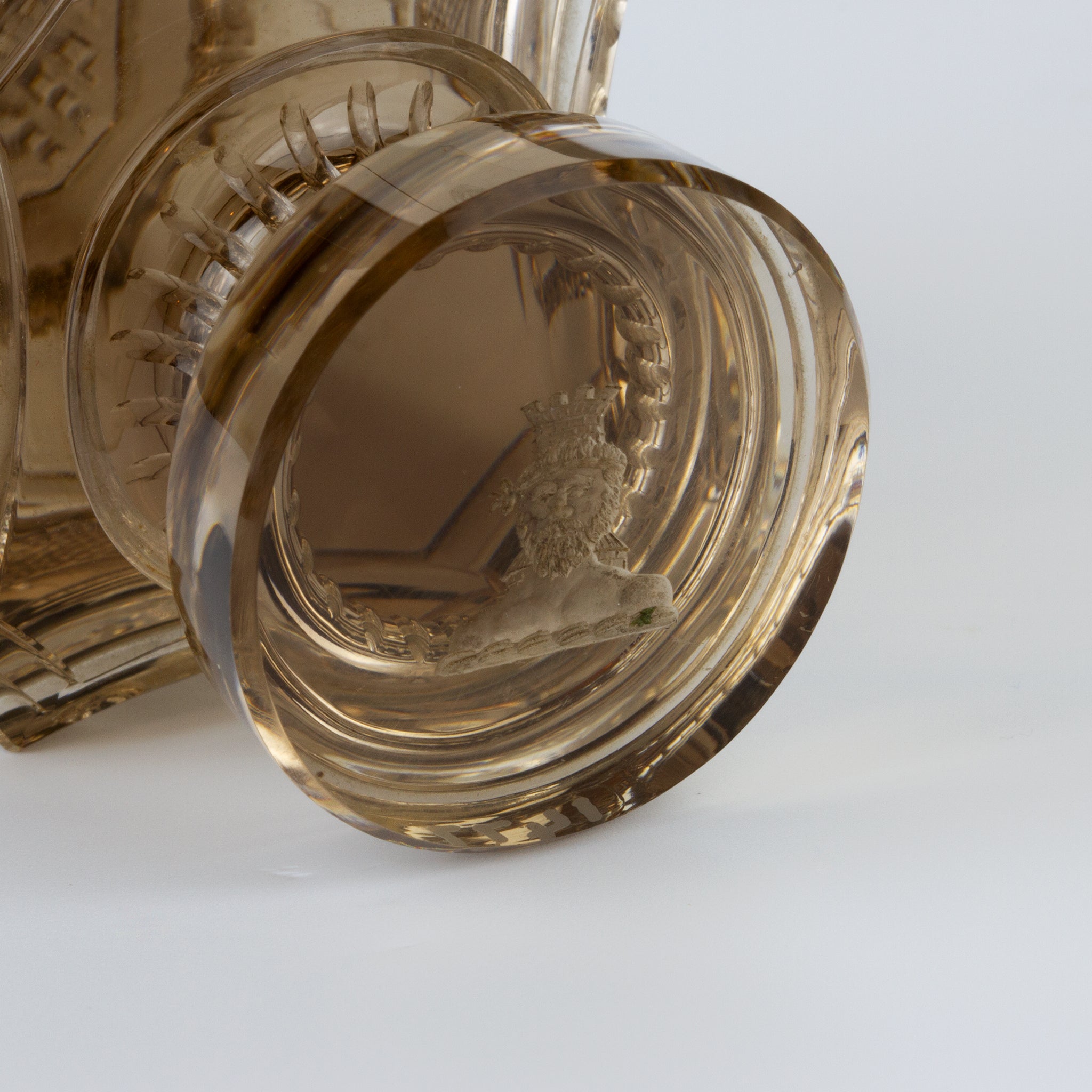 Closeup of engraved crest of man's head and castle tower on smokey glass wax seal