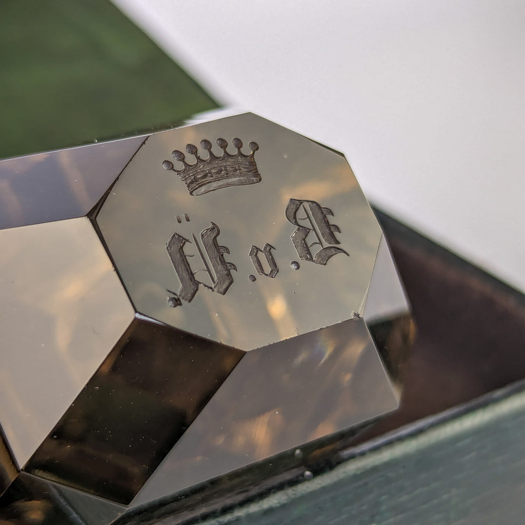 Closeup of matrix on antique wax seal showing crown and initials