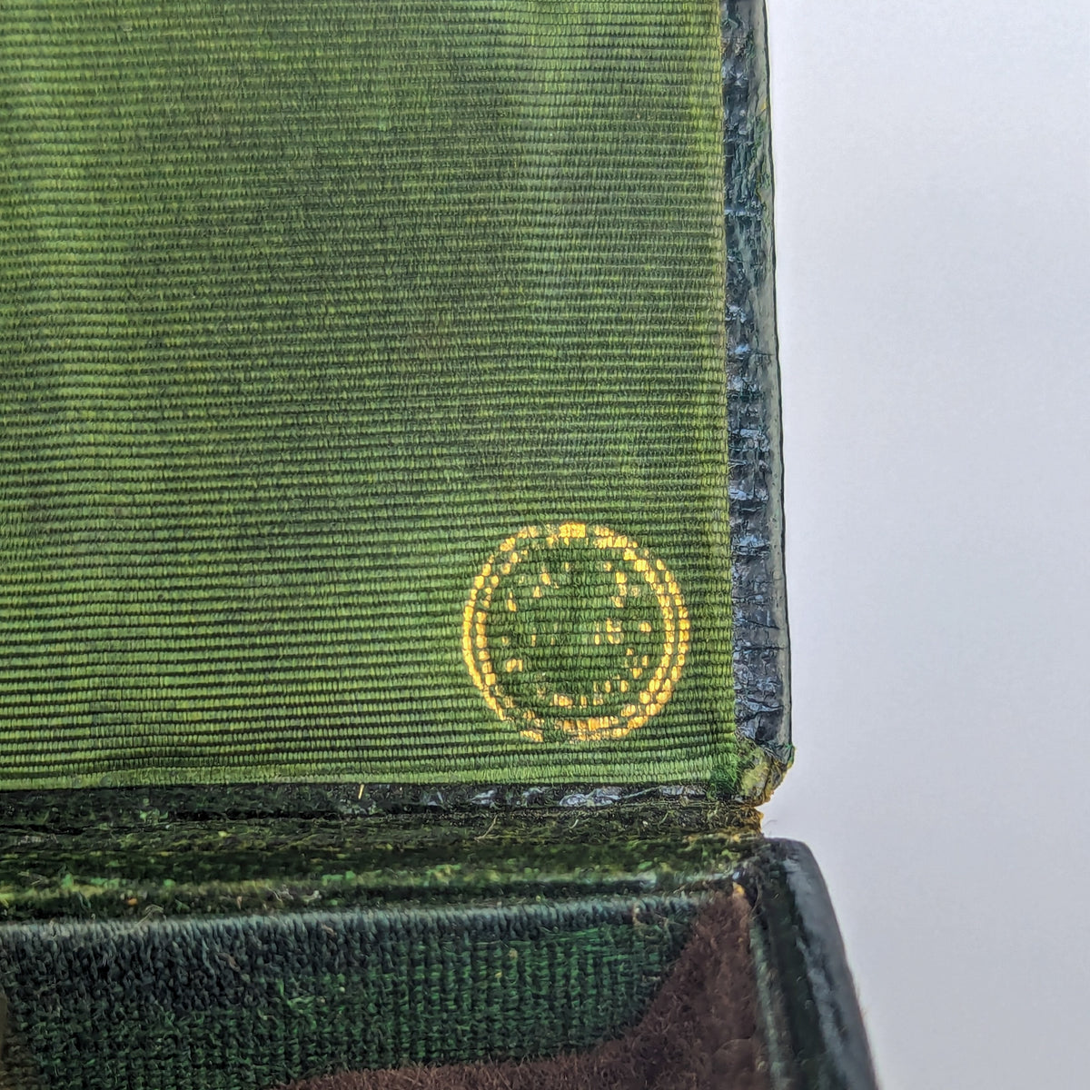 Detil of gold mark inside black leather wax seal case