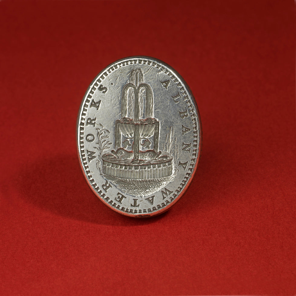 Closeup detial of the silver wax seal matrix for Albany Water Works