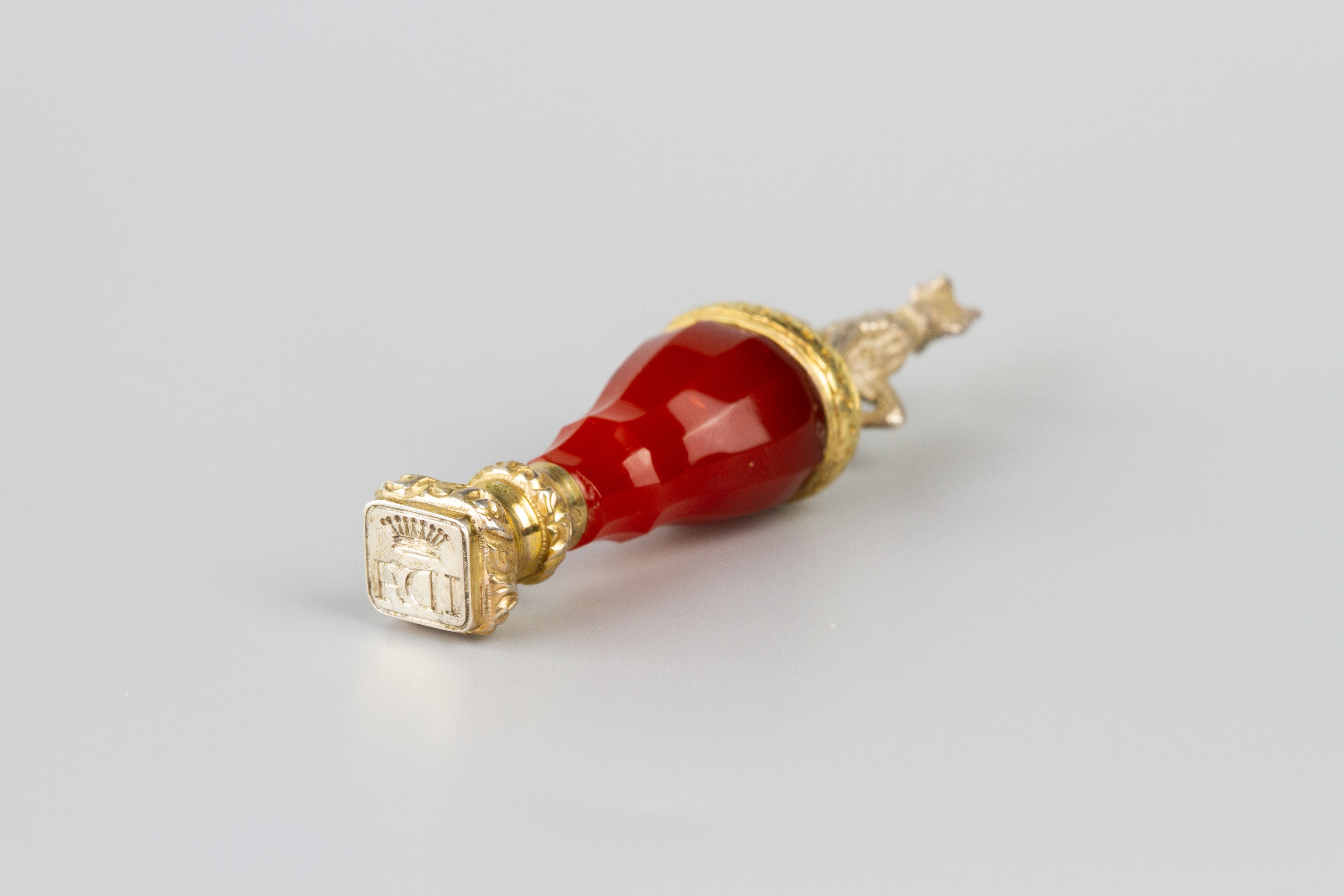 Red handle and gold mount wax seal with crown and initials with whippet dog figurine on top