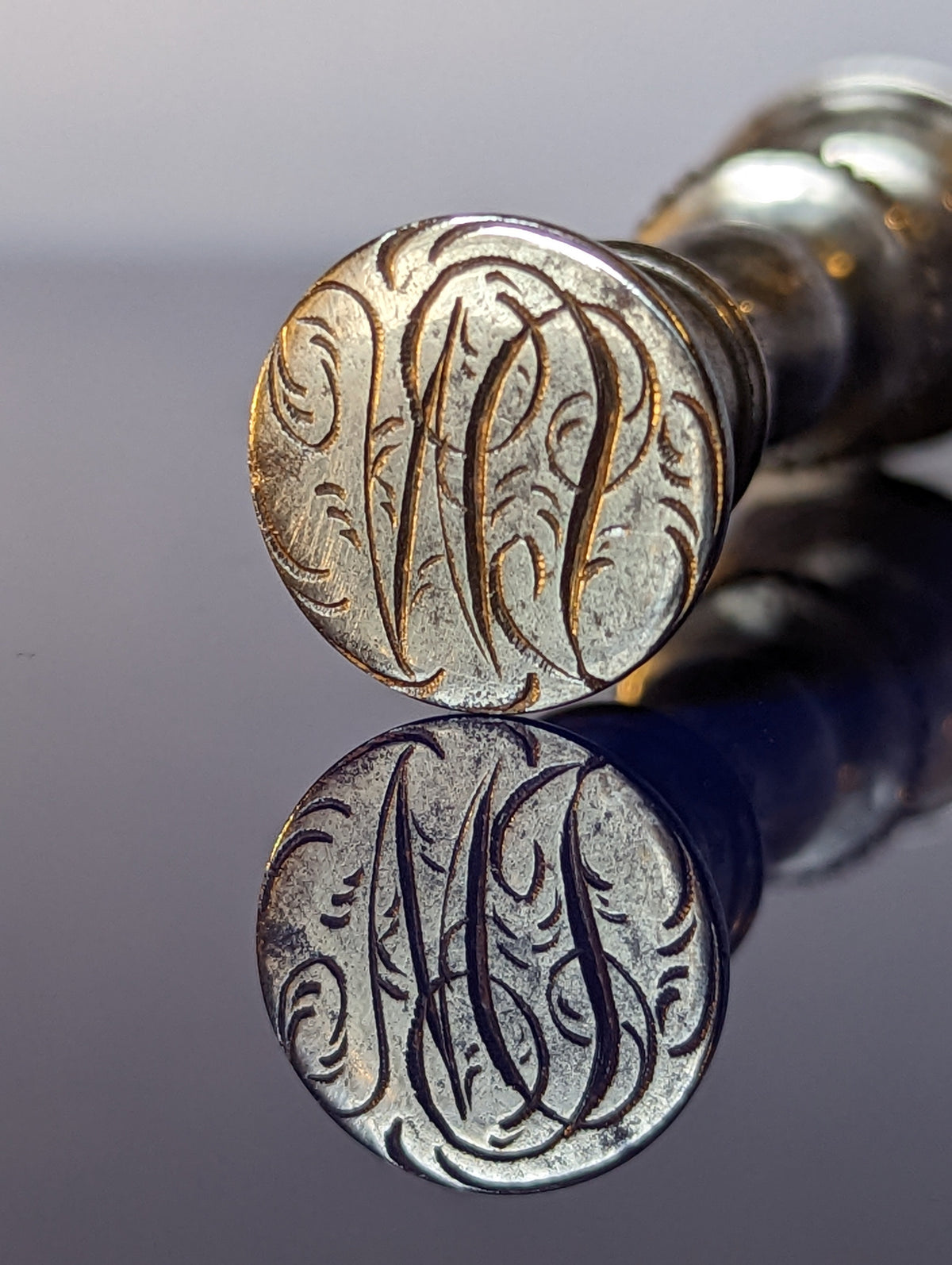 Closeup of matrix showing engraved cypher on antique wax seal