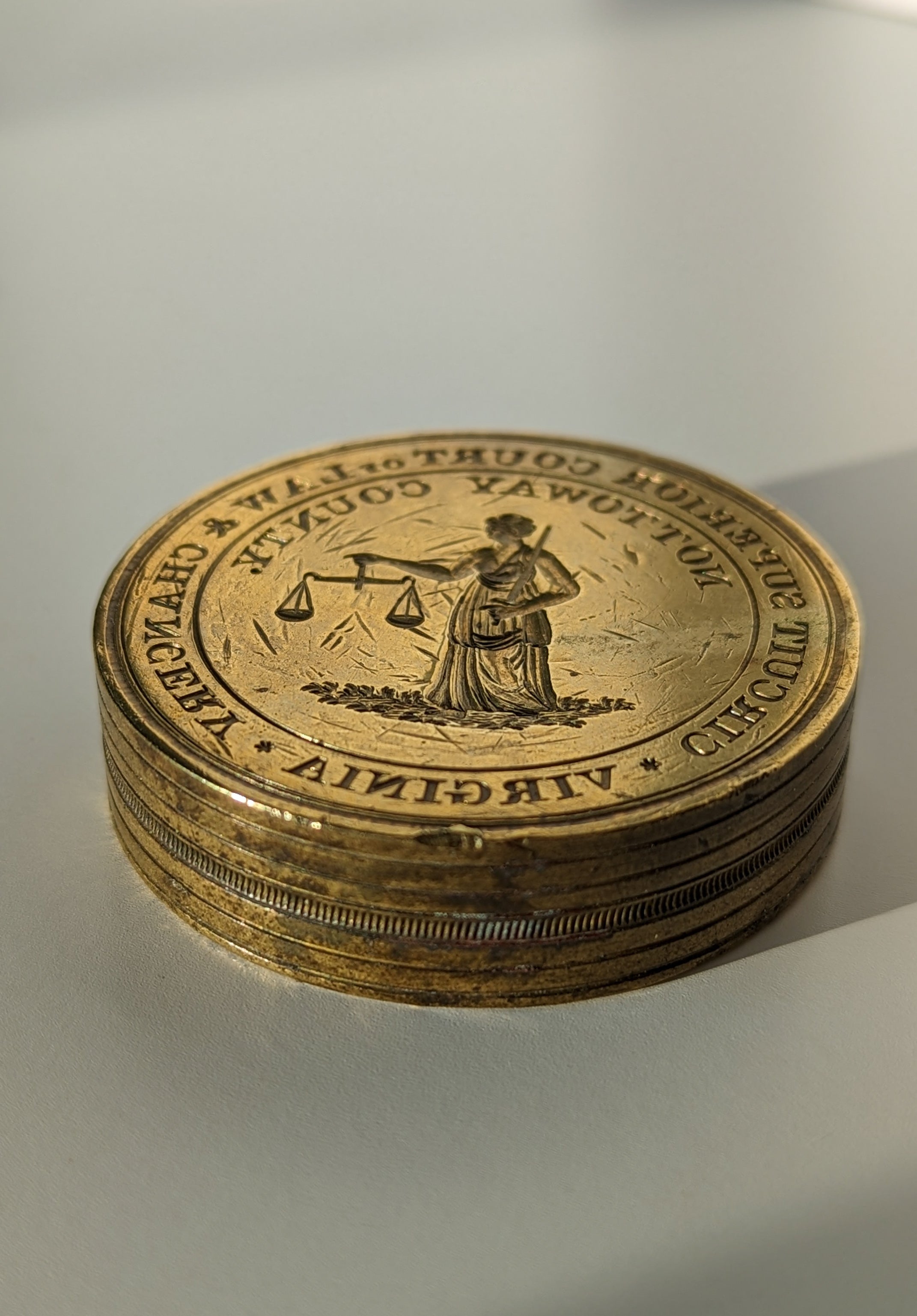 Closeup of antique American wax seal with engraving of lady holding scales and a circumscription  