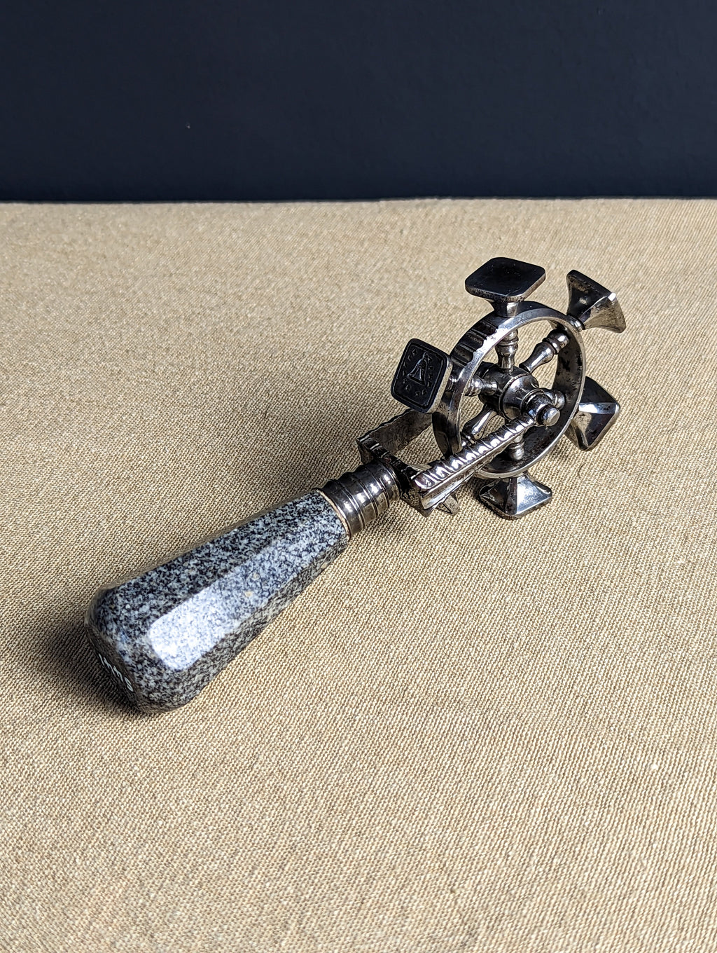 Three quarter view of granite and steel spinning wheel desk seal