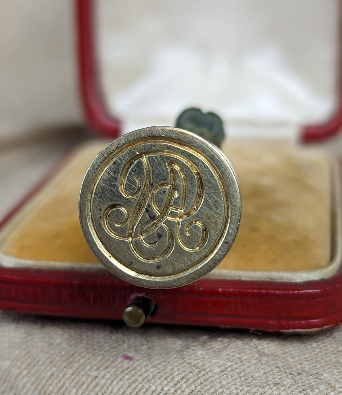 Detail of silver matrix with cypher on wax seal and red leather case