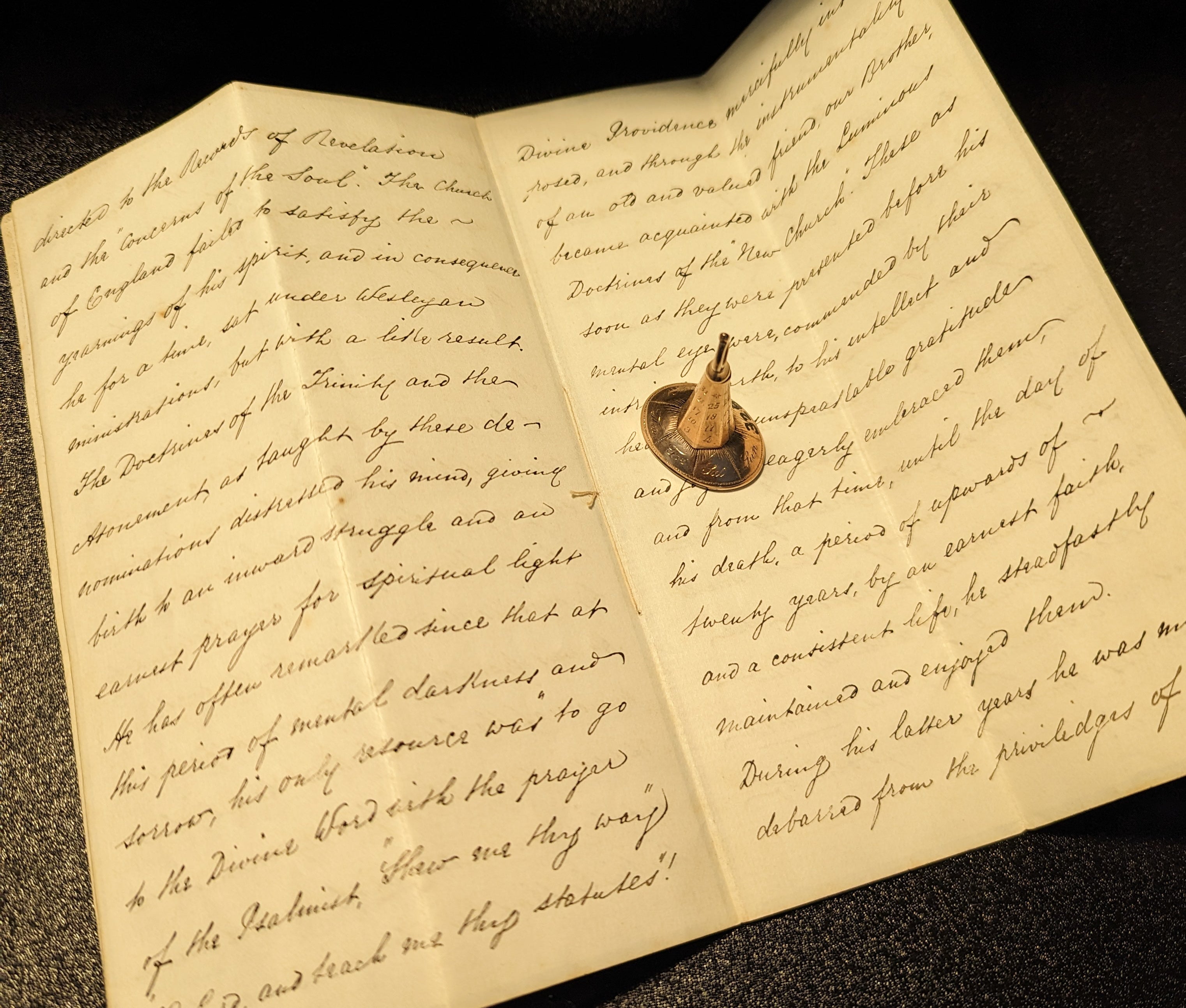 Gold perpetual calendar fob seal sitting on old handwritten letter